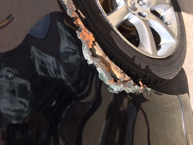 Before: 2004 Infiniti quarter panel with heavy rust corrosion behind the rear wheel