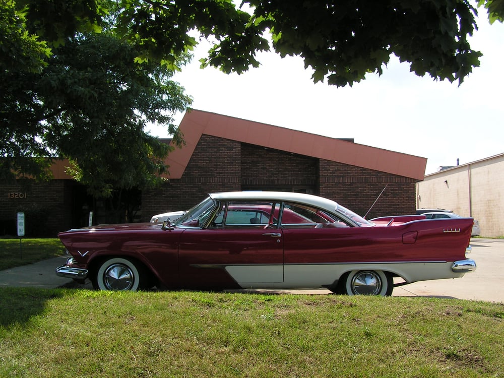 Delivered: two-tone deep maroon and cream 1950s Plymouth hardtop coupe with whitewall tires on the lawn