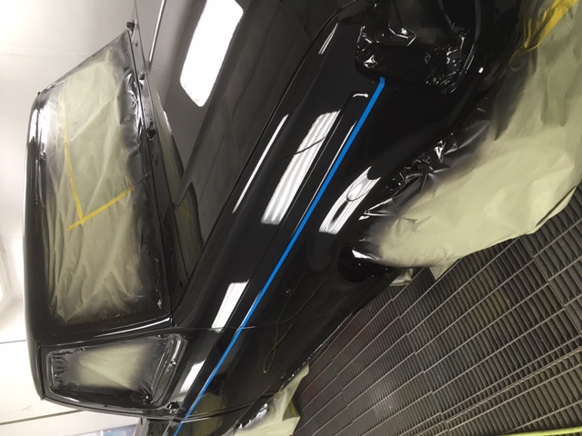 After: mirror-black Ford F150 quarter reflecting the booth lights