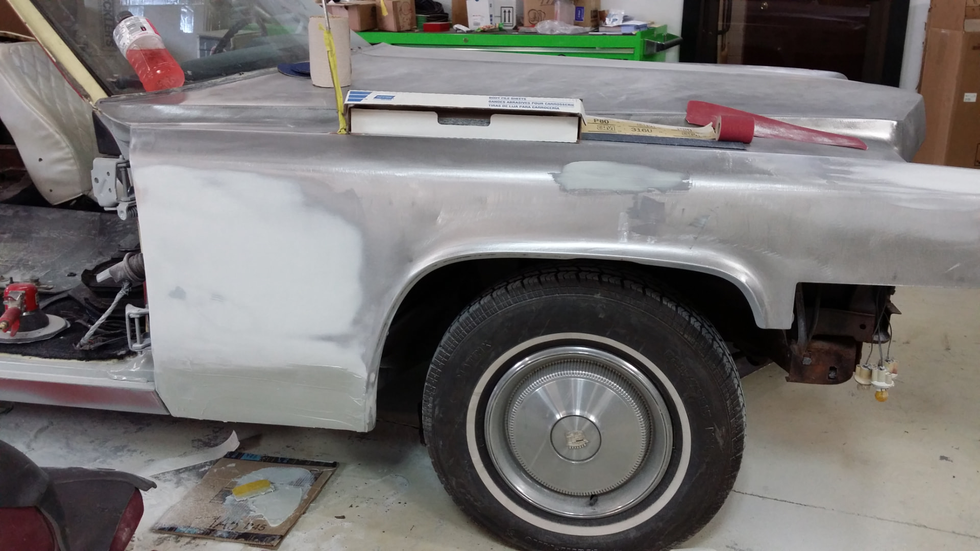 During: body filler blocked and sanded on the Cadillac front fender with sanding tools resting on the panel