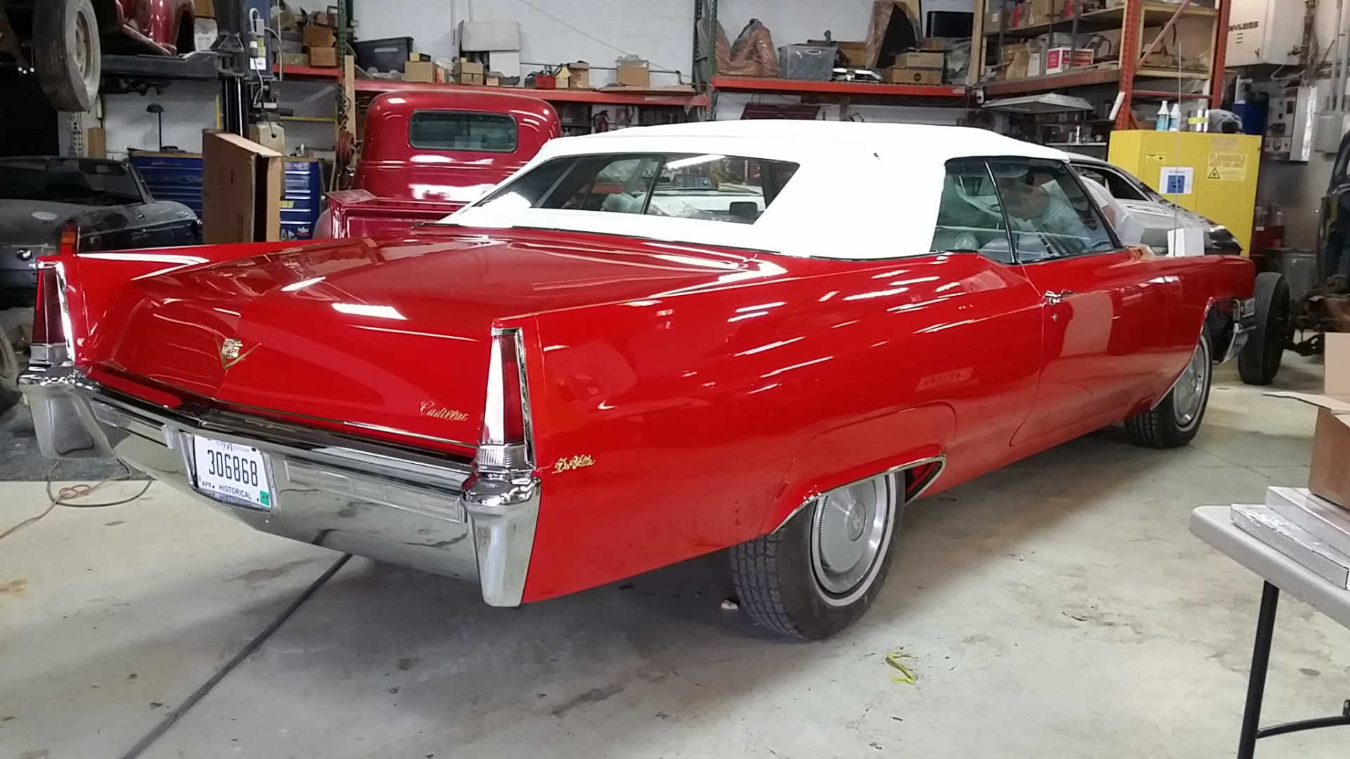 After: completed 1969 Cadillac DeVille convertible in deep red with a white convertible top and bright chrome